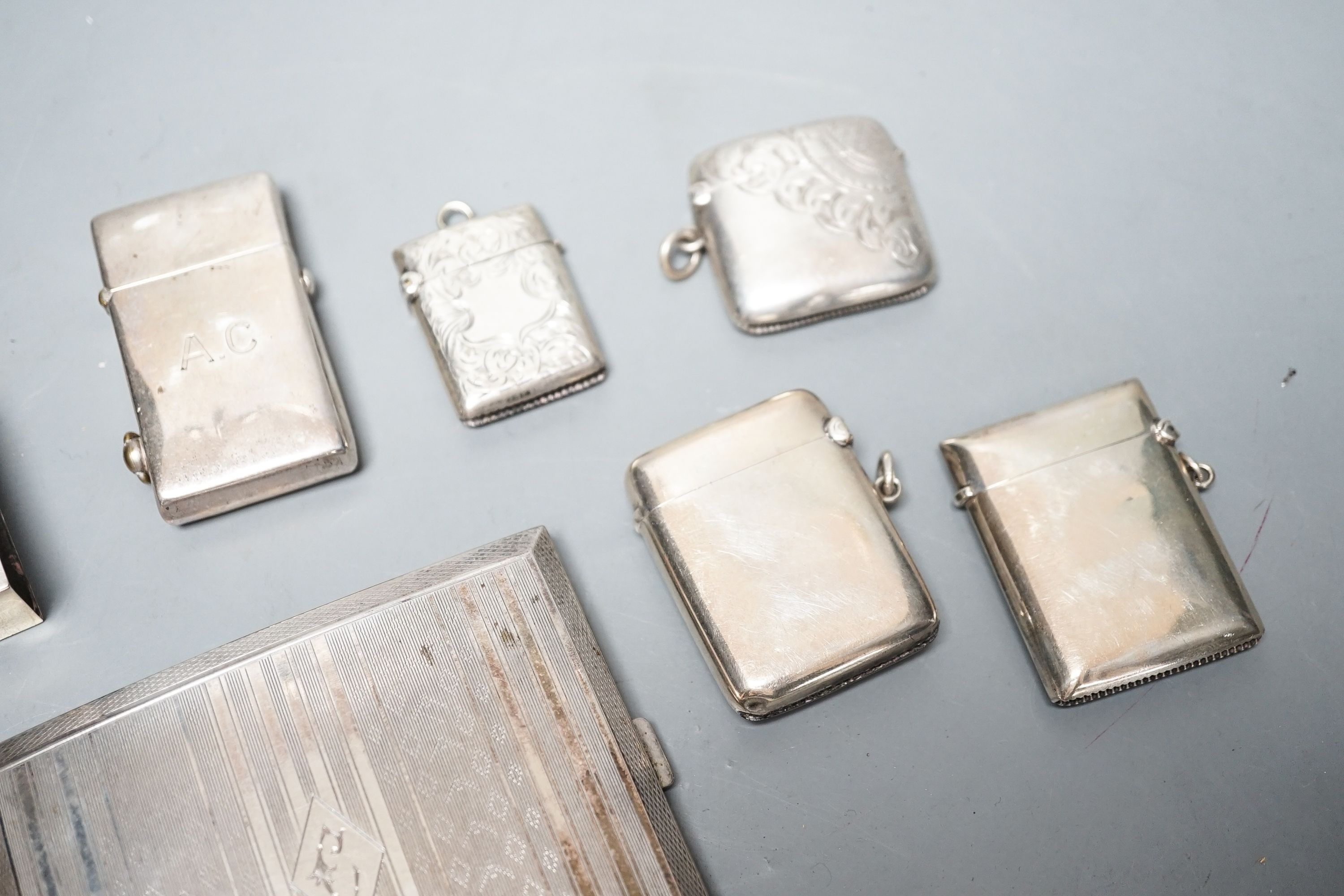 A group of assorted small silver to include four vesta cases, two cigarette cases (one plated), a card case, pill box, match sleeve and white metal mounted lighter.
